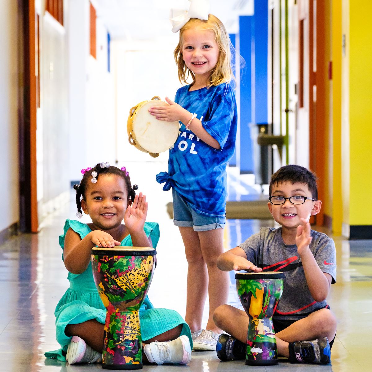  A group of smiling magnet students play instruments in a hallway